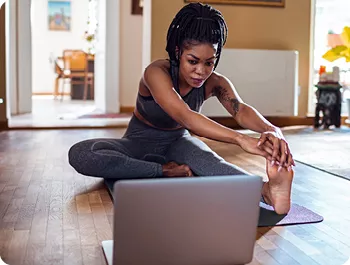 Woman participating in virtual fitness class at home